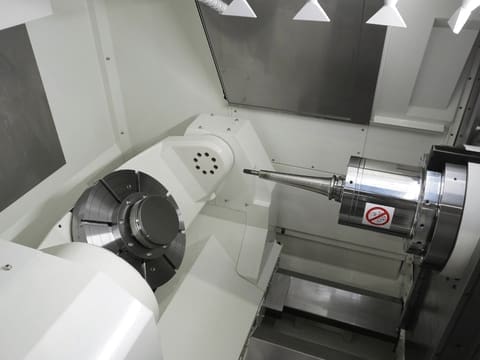 Close-up of Kitamura Supercell 300G performing high-precision 5-axis machining on a complex metal component.
