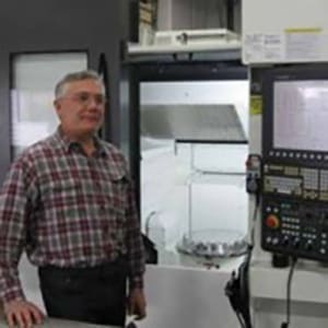 A person standing next to a machine.